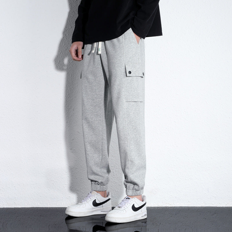 Men's knitted cotton casual trousers in light gray with elastic waistband and drawstring, suitable for sports and leisure.