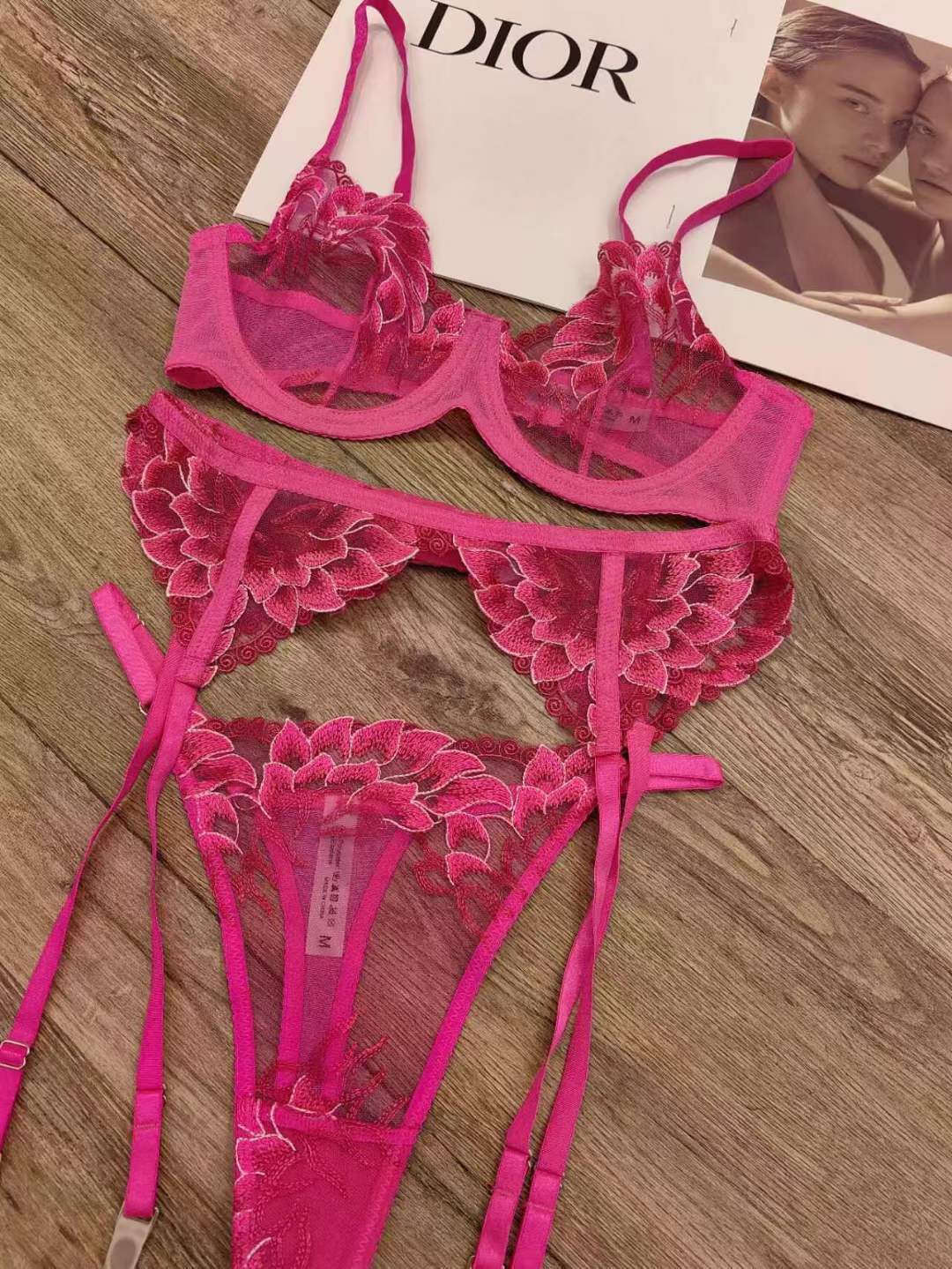 Anti-sagging Lace Embroidery Three-piece Set in Rose Red with elegant lace details on a wooden background.
