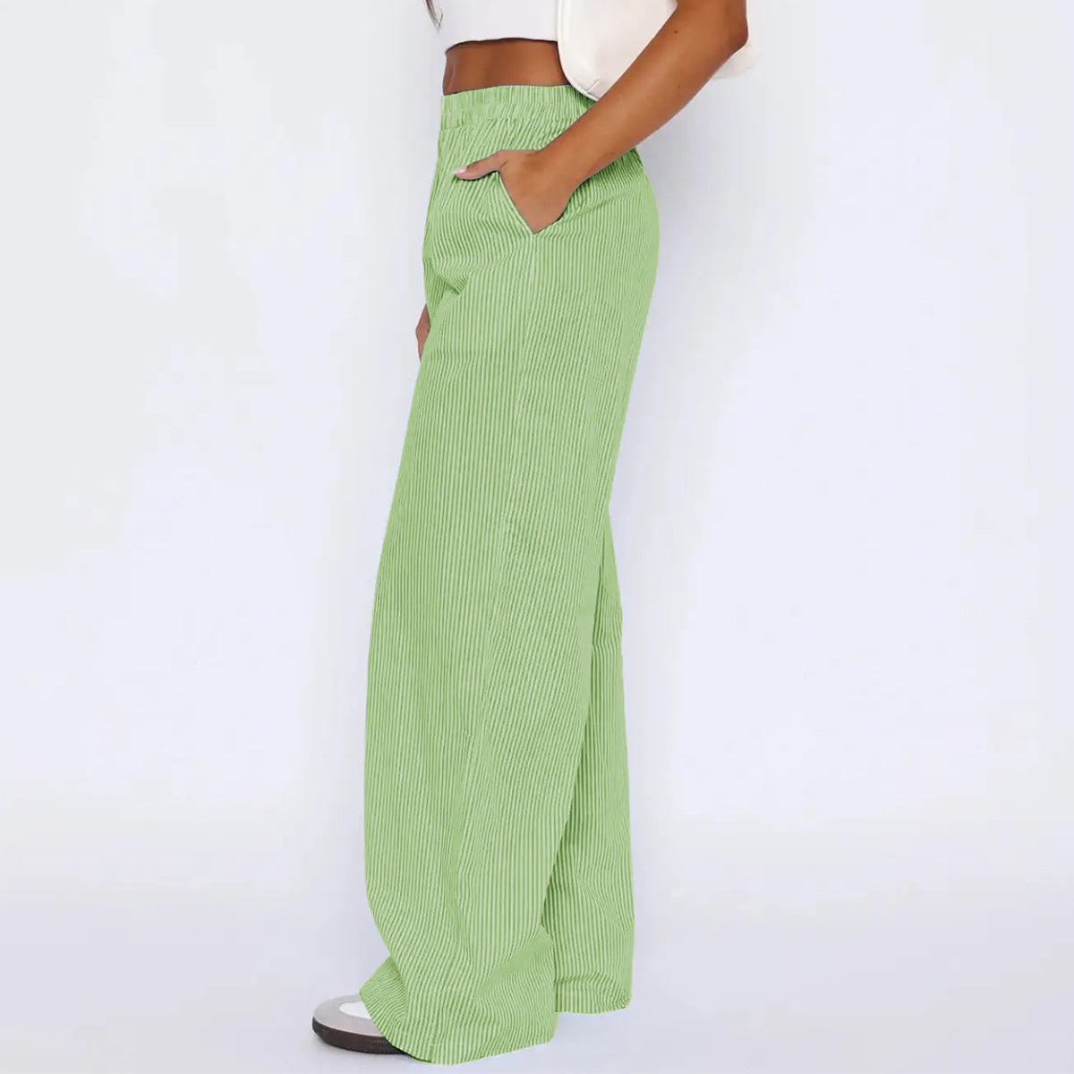 Green striped trousers with pockets, high waist, loose fit, stylish design.