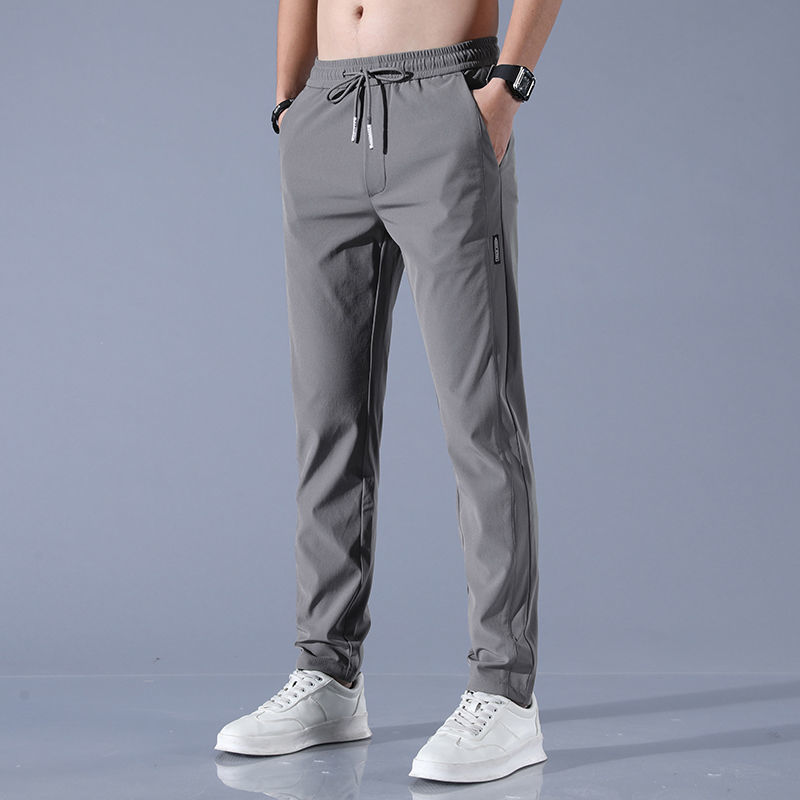 Men's plus size fashion straight pants in gray, modeled with white sneakers and black watch.