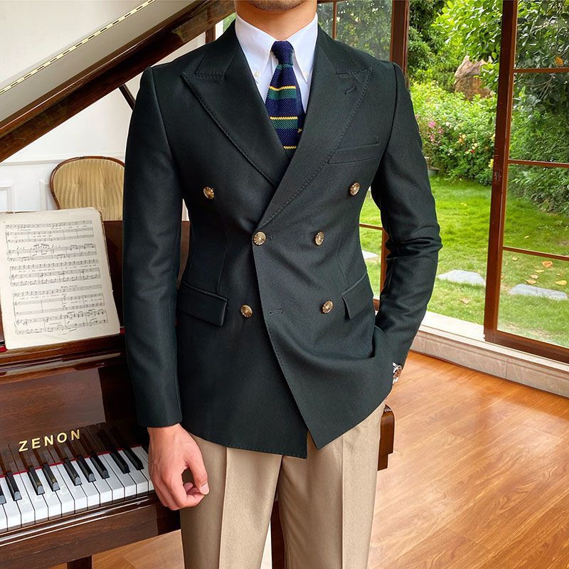 Casual business all-match double breasted suit jacket in dark color, showcased indoors next to a piano.